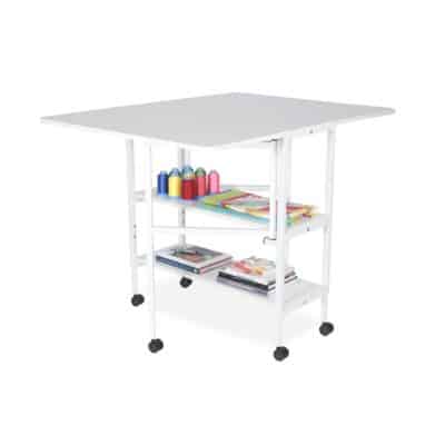 Dixie Cutting Table is designed to be a dynamic, durable and dependable addition to your sewing area, featuring 6 heavy-duty locking casters for stability and easy mobility, dual shelving units to store sewing and crafting accessories, and an optional 46″ x 34″ pinnable cutting mat!