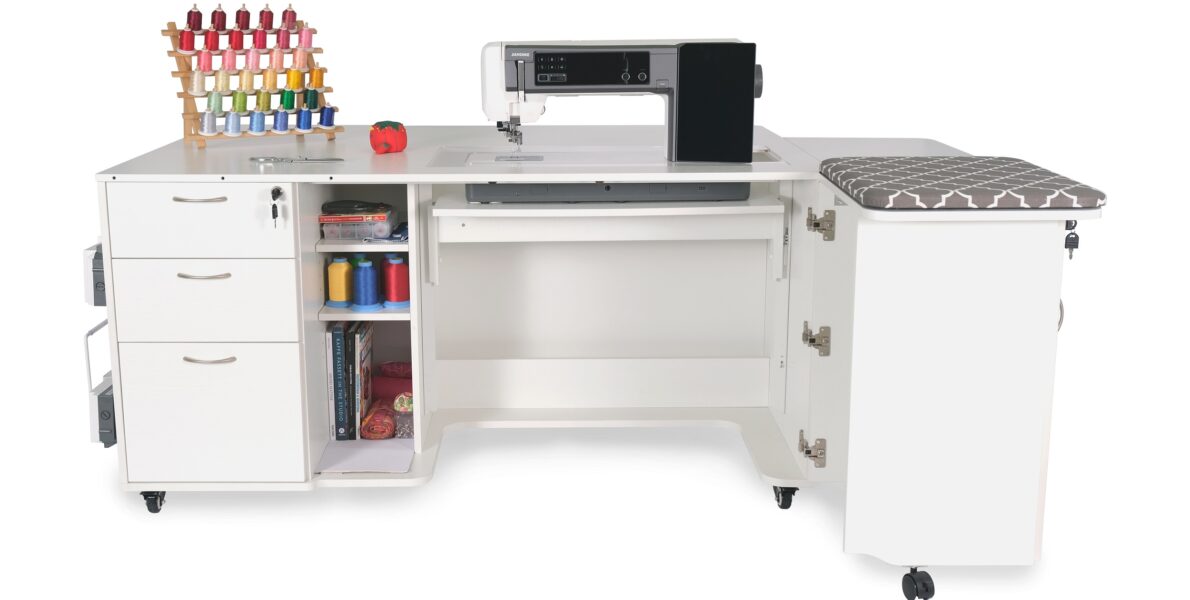 Sydney Hydraulic XL Sewing Cabinet features a rear quilt leaf, side leaf, tri-fold door with flip-up tabletop, pressing mat, drawer cover, embroidery spool holder, removable drawer tray insert, and innovative space for storing your embroidery arm. Shop at Arrow Sewing.